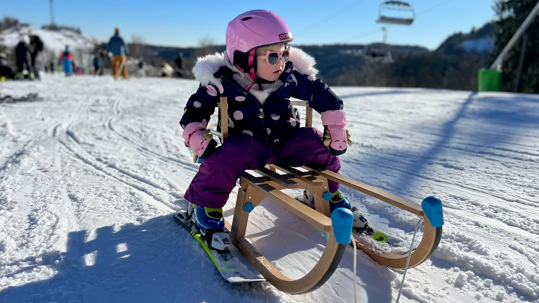 Klein kind op ski's op slee