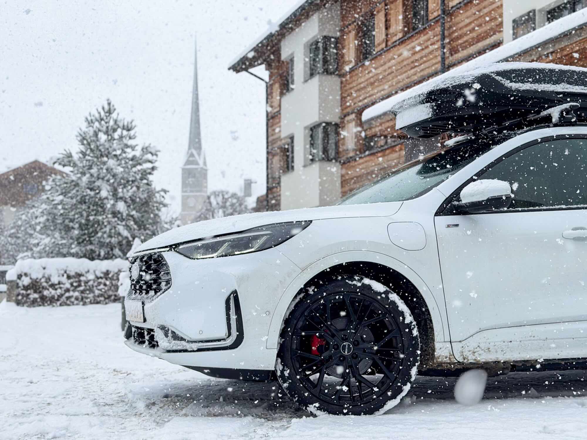 Auto mit Dachbox im Schnee